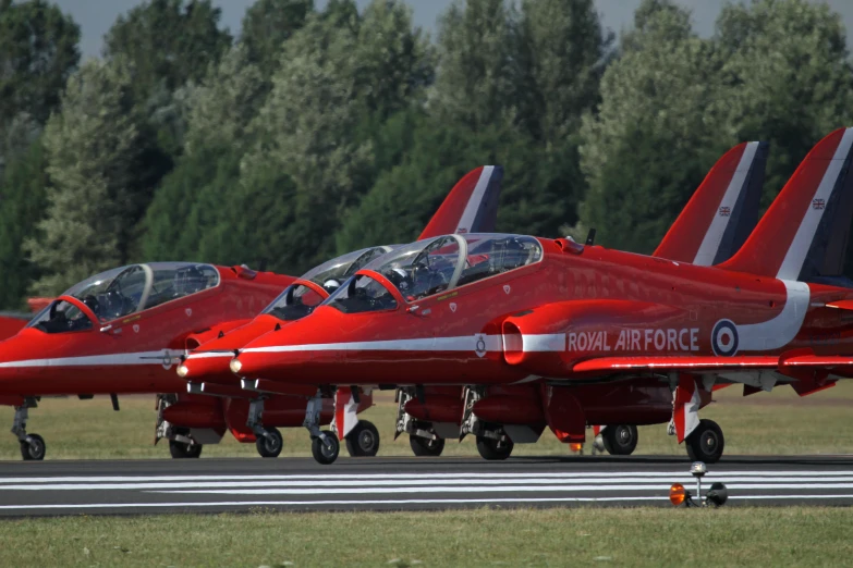 several red jet planes lined up for takeoff