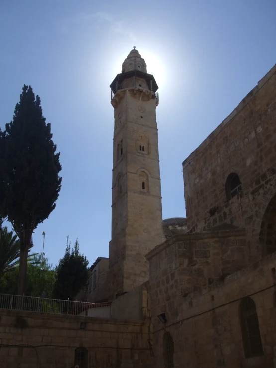 a clock tower stands in the shadow of an old building