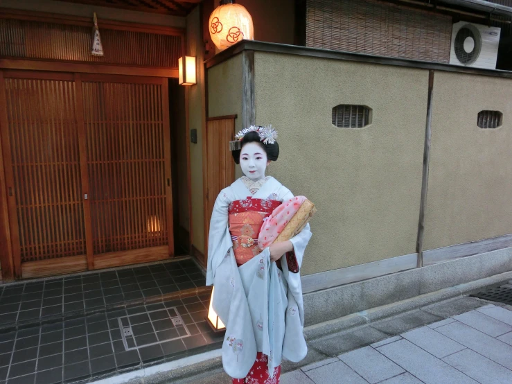 a lady in geisha clothing holds a piece of bread