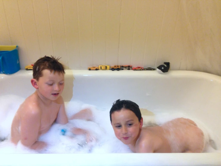 two children are in the bathtub playing with each other