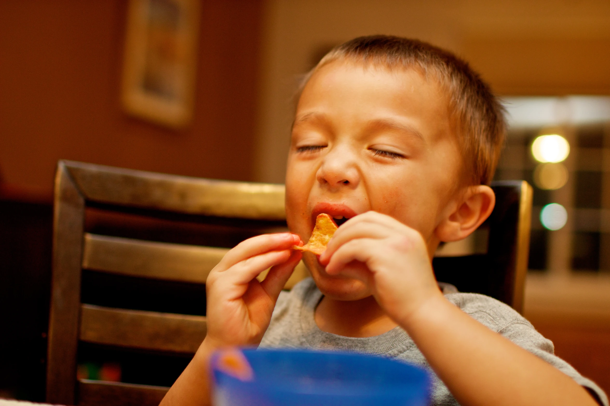 there is a small boy eating pizza on a table