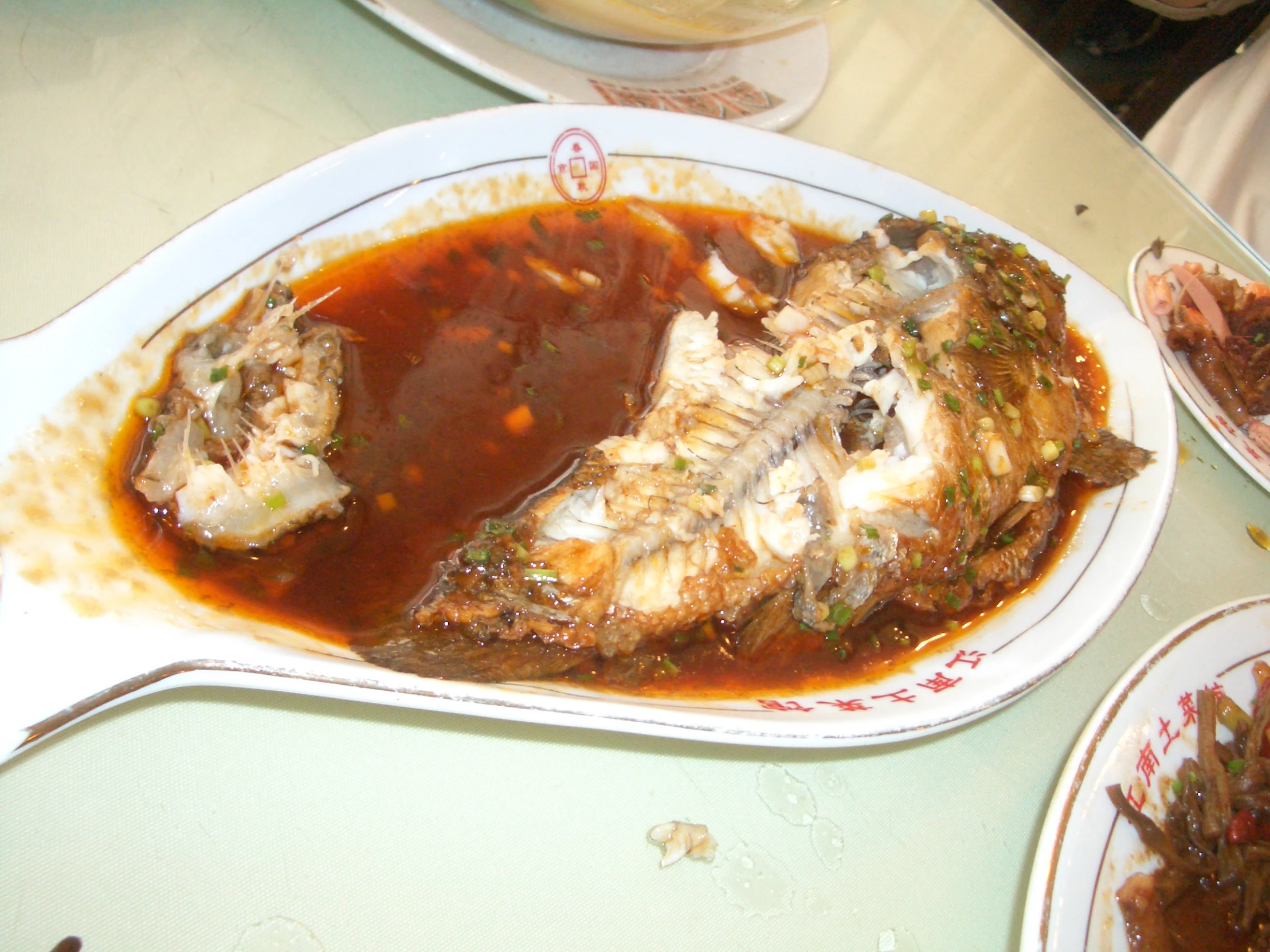 two pieces of fried fish in sauce and brown sauce