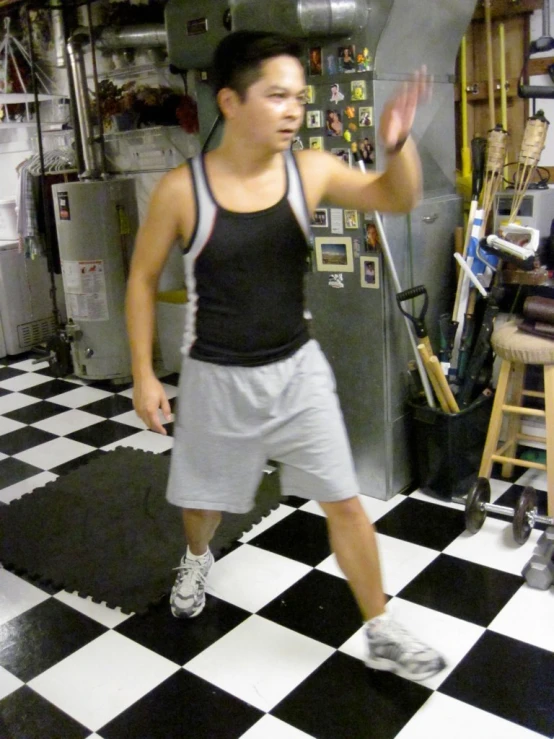 a man is walking across a kitchen floor while using his cell phone