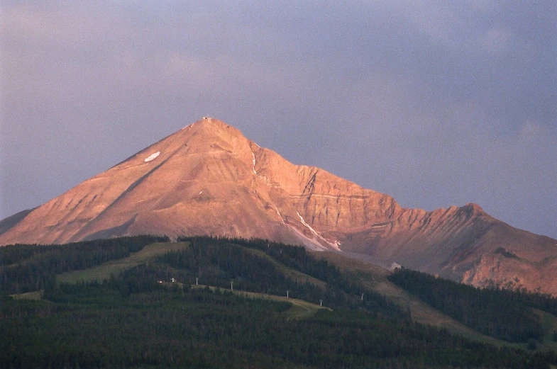 a mountain is in the distance with trees near by