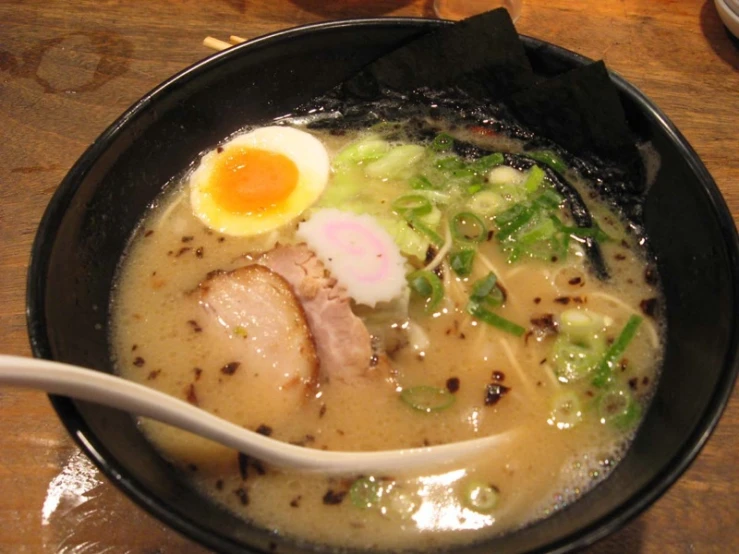 a bowl with noodles, broth, eggs and meat