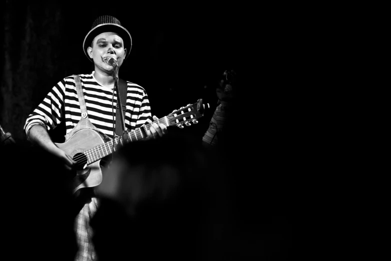 the man is playing the guitar in the dark