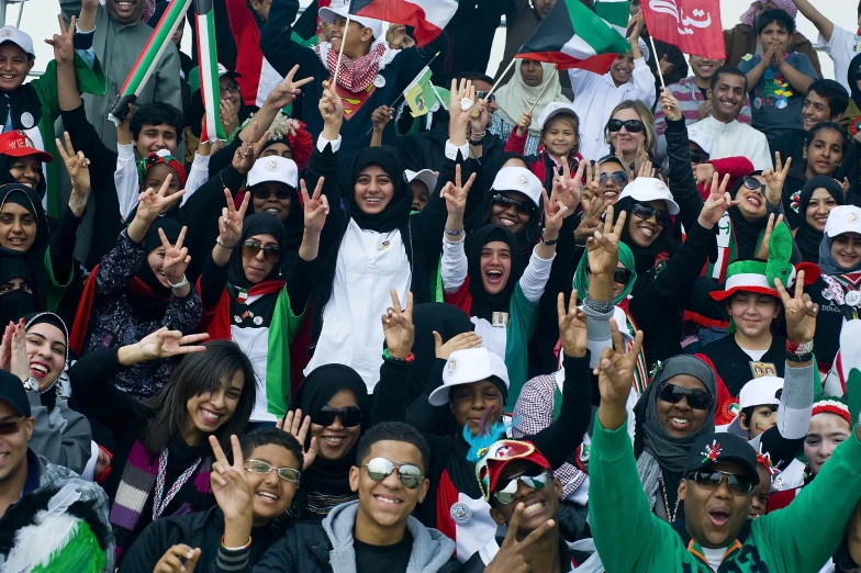 a bunch of people posing for the camera with their hands up