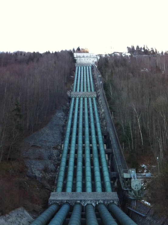 a large pipe next to a forest covered in snow