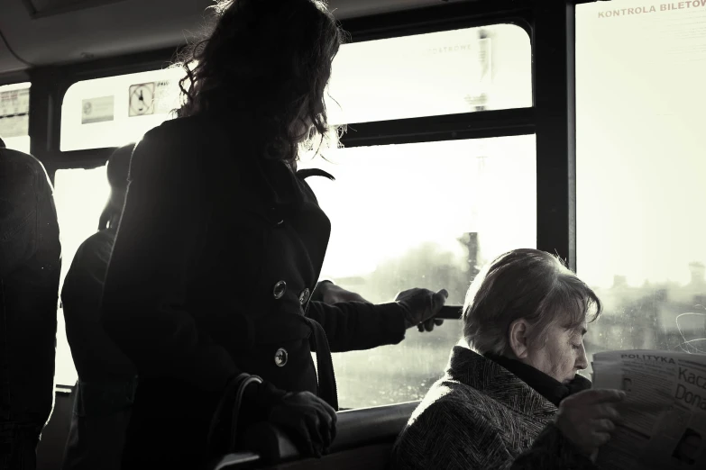 a woman that is looking at her cellphone while on a train