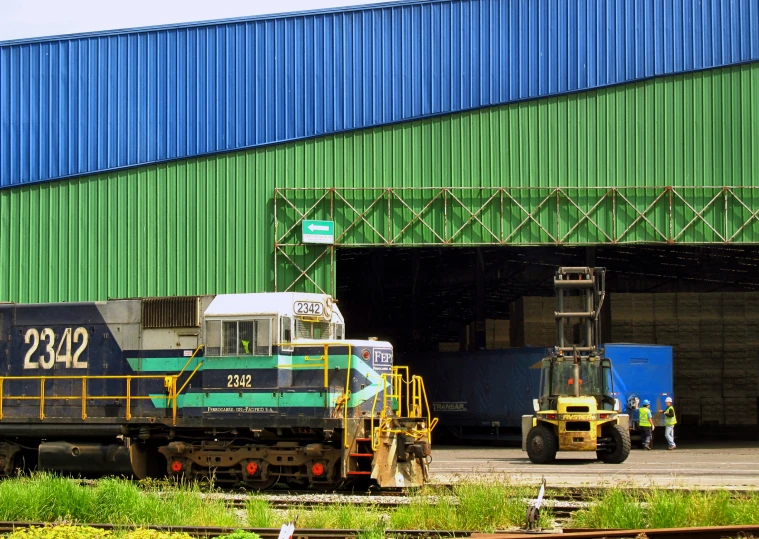 a train traveling under a blue sky next to a train station