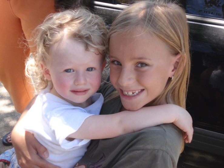 the mother hugs the daughter's face outside