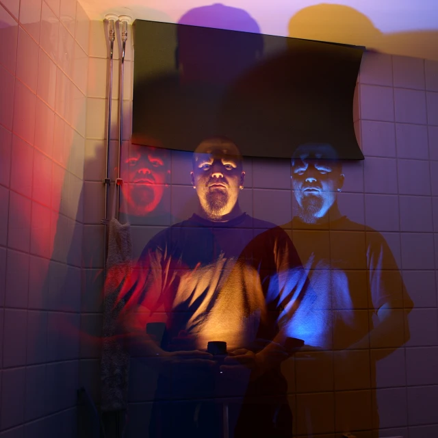 a picture of three people in a bathroom in the reflection