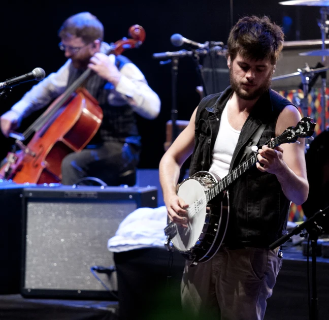 two musicians are playing and singing on stage