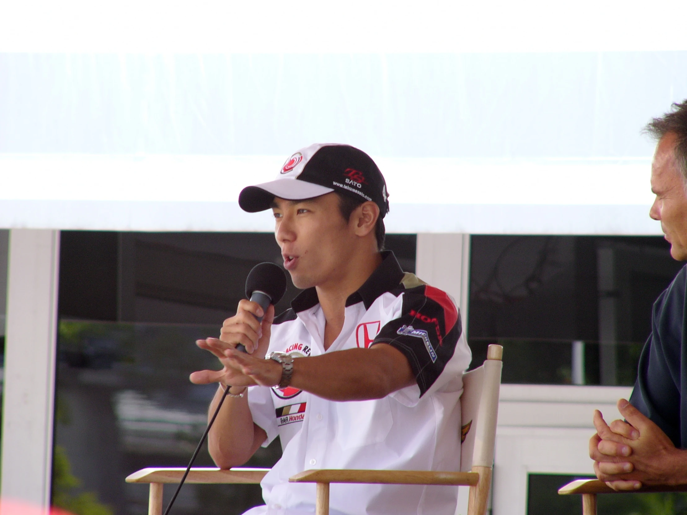 a man holding a microphone sitting next to another man