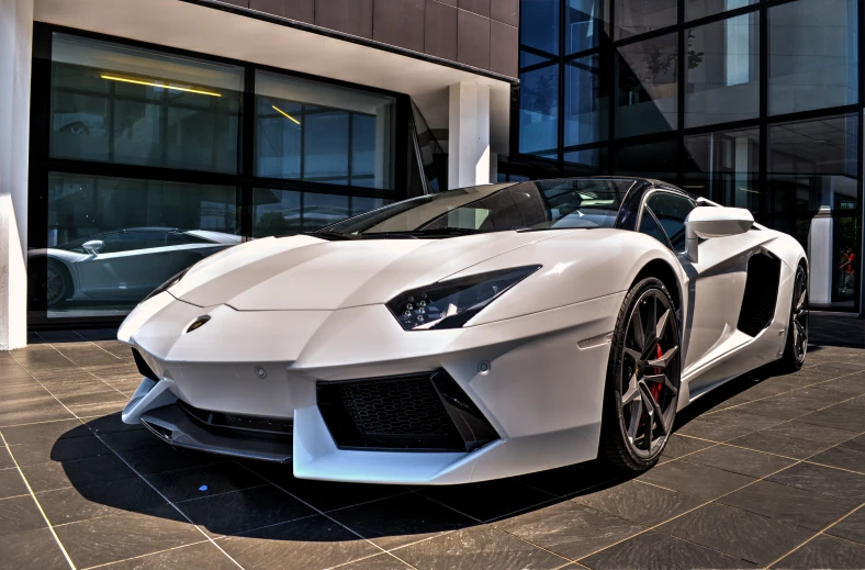 a white sports car is parked in front of a building