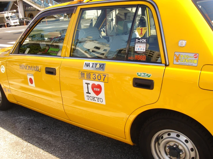 a yellow cab driving down a street next to a building