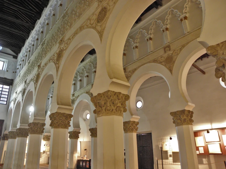 a large room with columns and a chandelier hanging from the ceiling