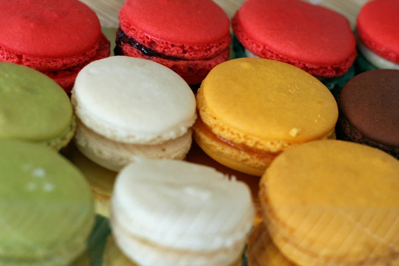 a table topped with lots of colorful cupcakes and pastries