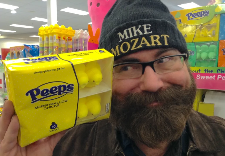 a man holding up a box of peeps in a store