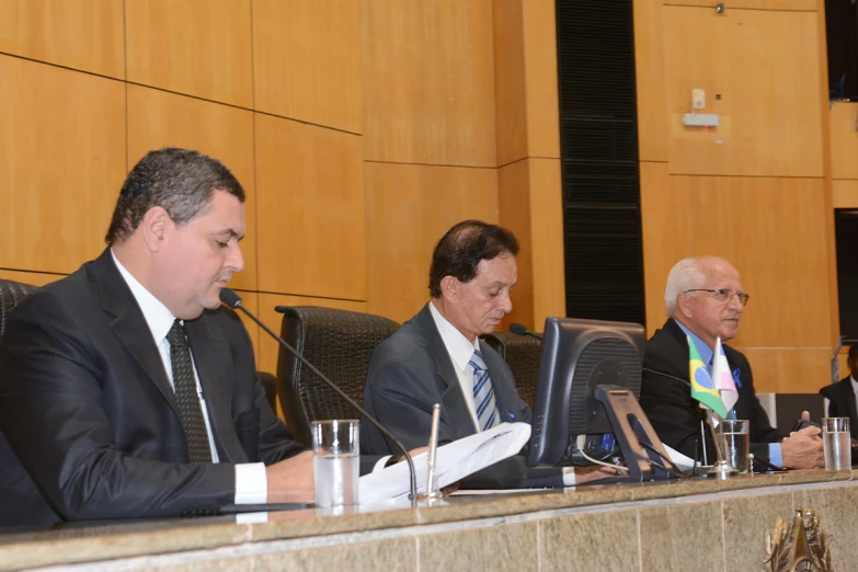 four men in suits sit at a table