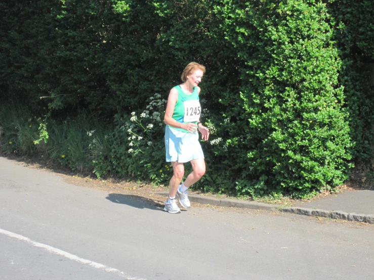 a boy is running down the street with a tennis racket in his hand