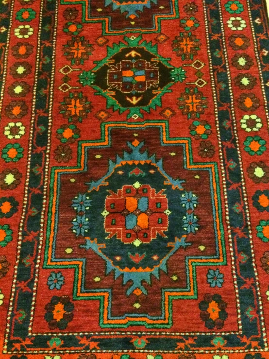 a red rug has various colored ornaments on it