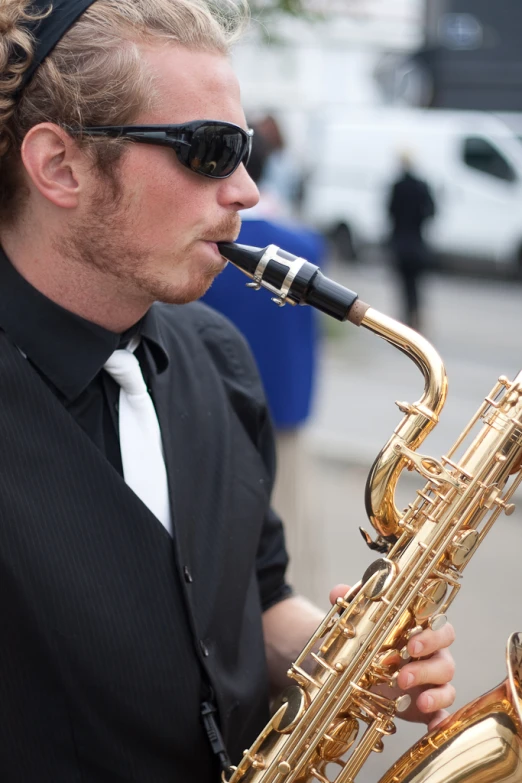 a man is playing on a ss saxophone