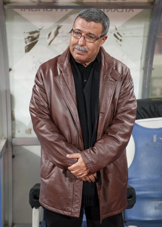 a man in a brown jacket standing up