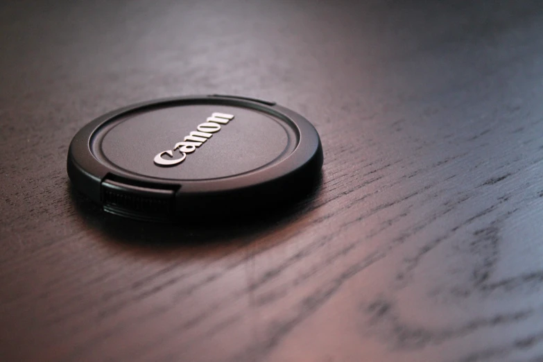 close up of a black circular object on a wooden table