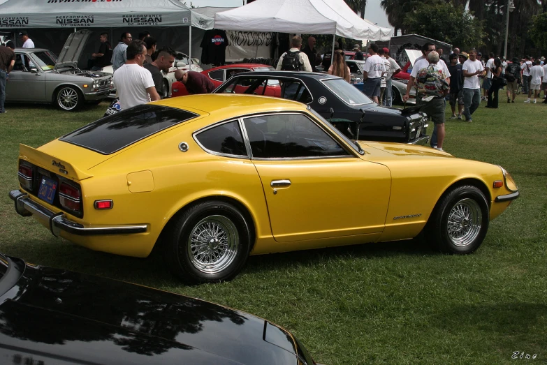 a yellow car at an event with other cars