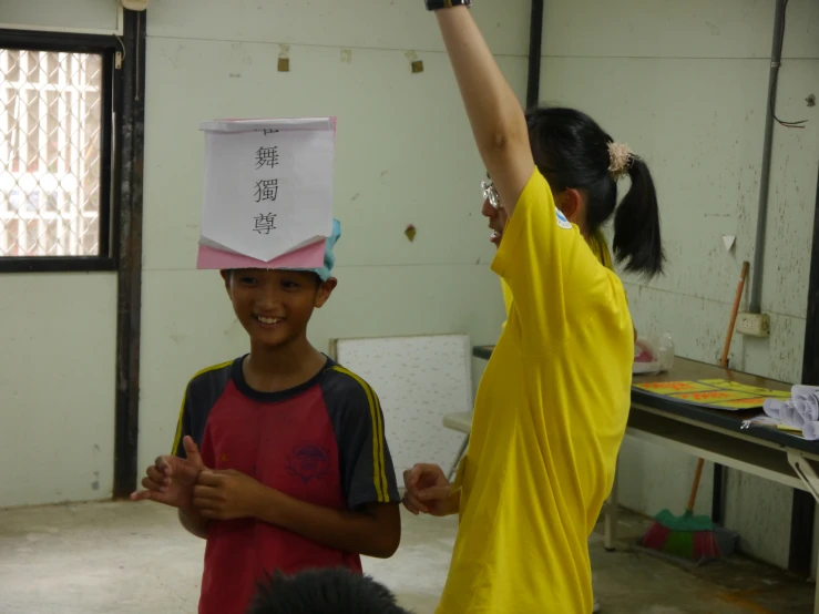 a child is holding up his paper head