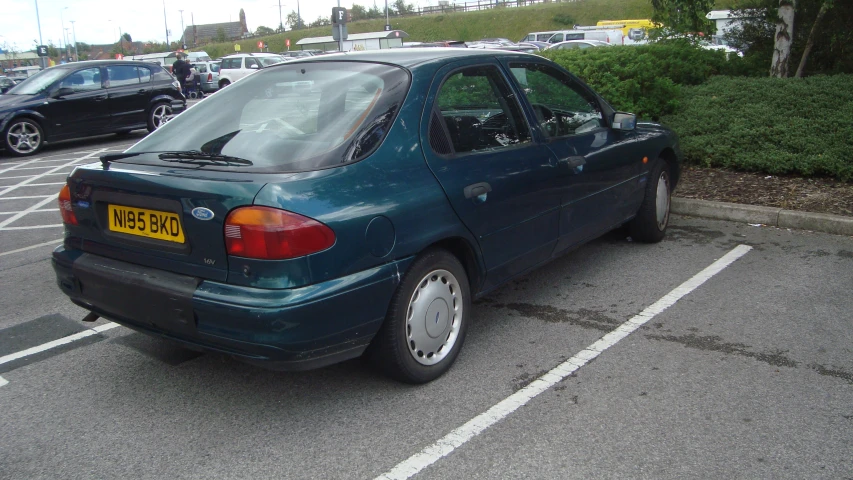 a car sits parked in a parking lot, waiting for passengers