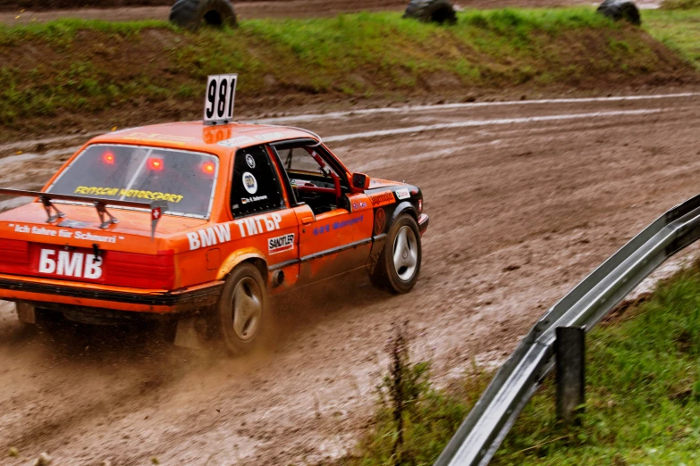 a dirt race car driving down a muddy road