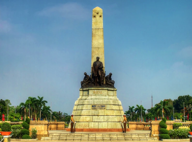 the statue has four soldiers in their hands near a pillar