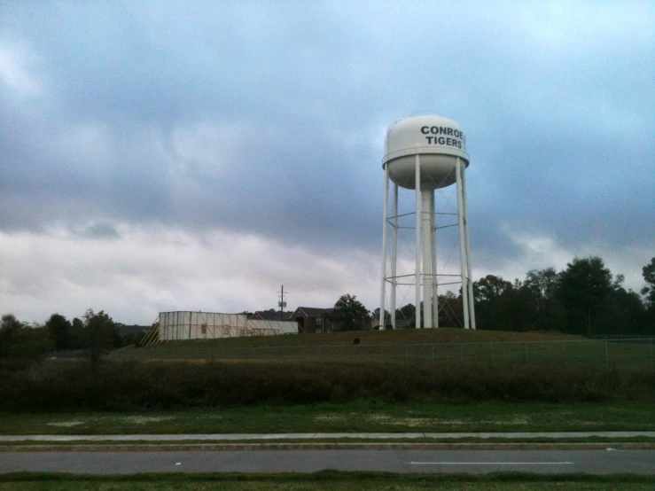a water tower near a street and grassy area
