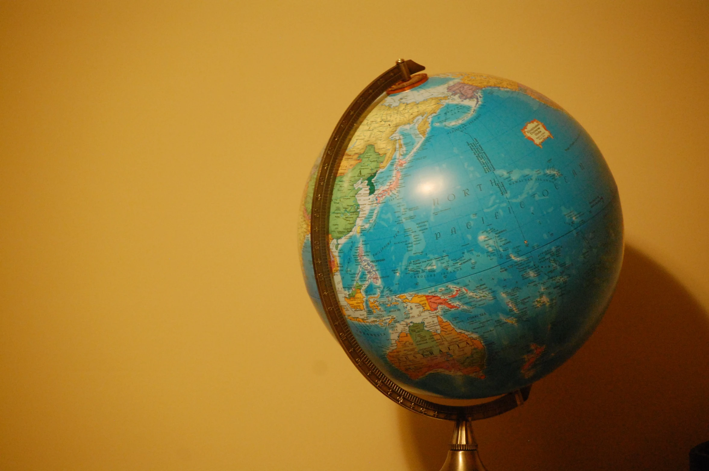 a blue and black globe is on a silver pedestal