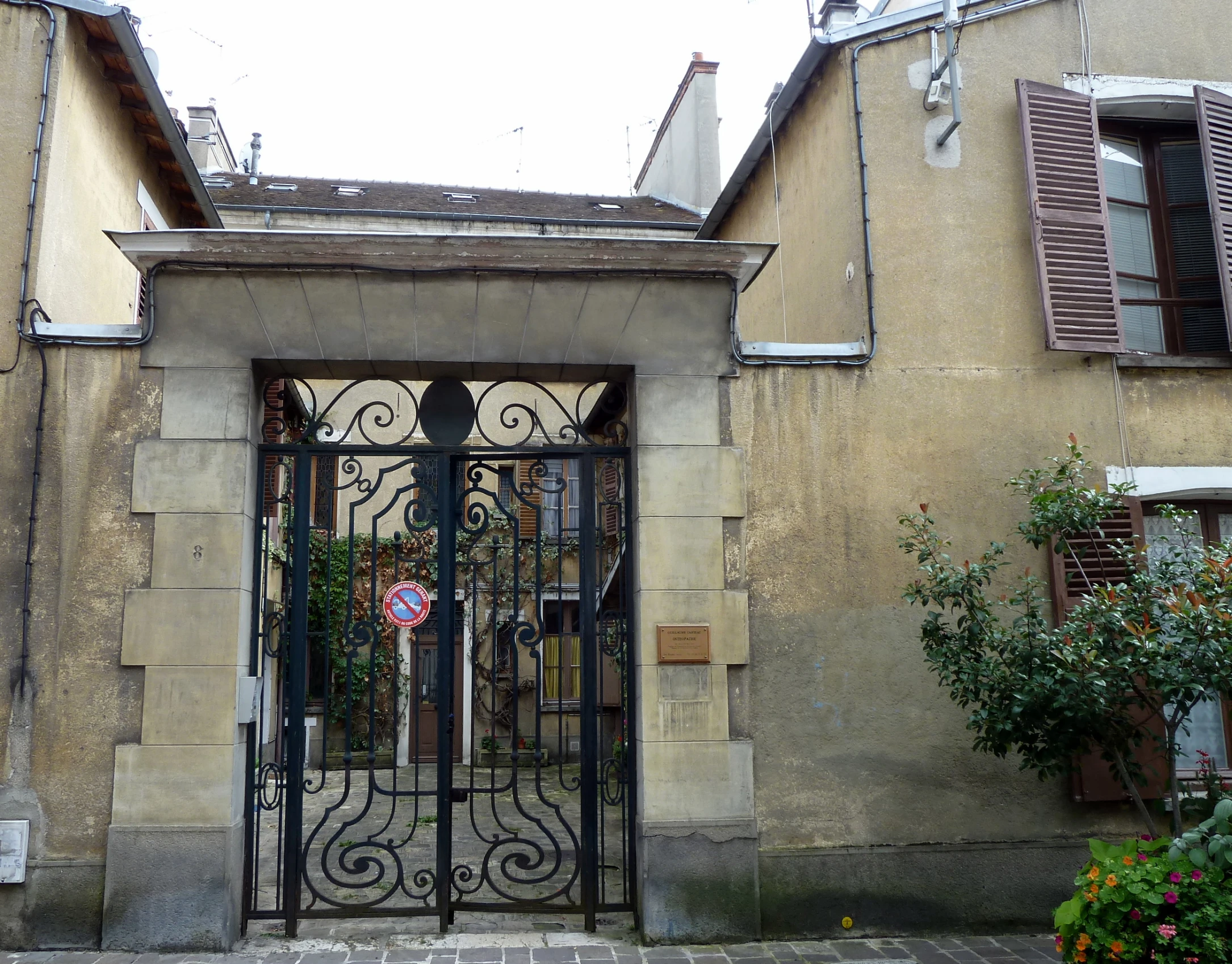 a gate with a pink wreath is opened on a building