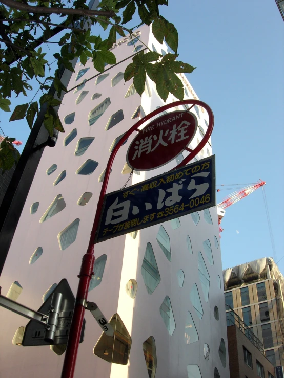 street signs displayed outside of large building on sunny day