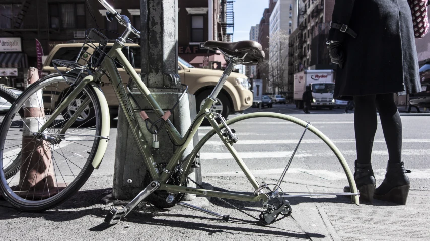 two bicycles locked to a telephone pole on the side of the road