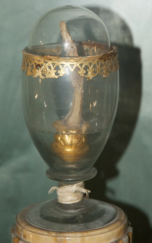 glass vase containing gold accents atop small wooden base