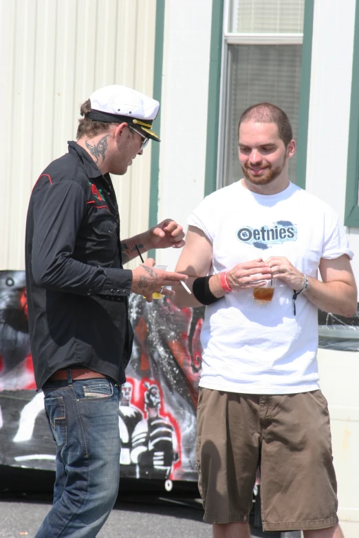 two young men standing outside of a truck talking to each other