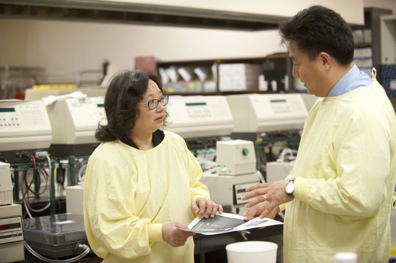 a man and woman standing in a lab with equipment