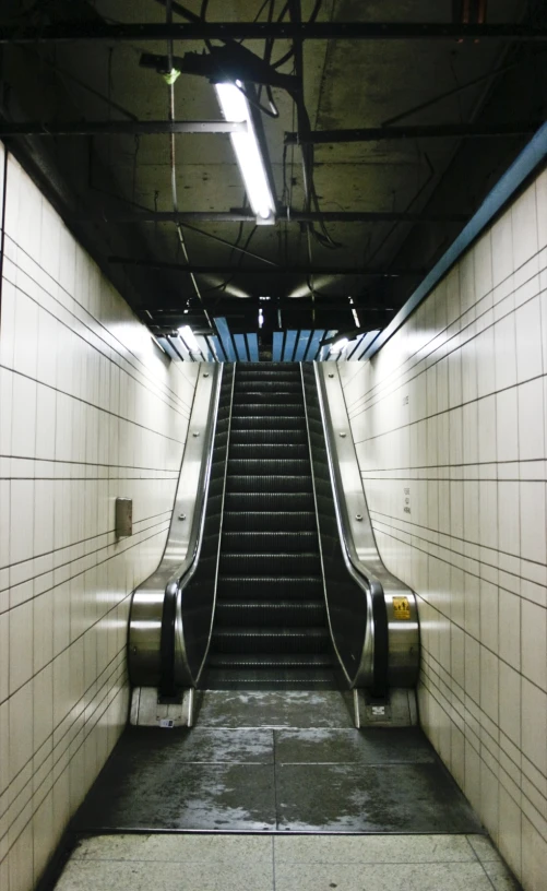 an escalator in an empty subway station