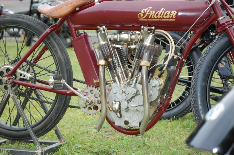 an antique motorcycle sitting on the grass outside