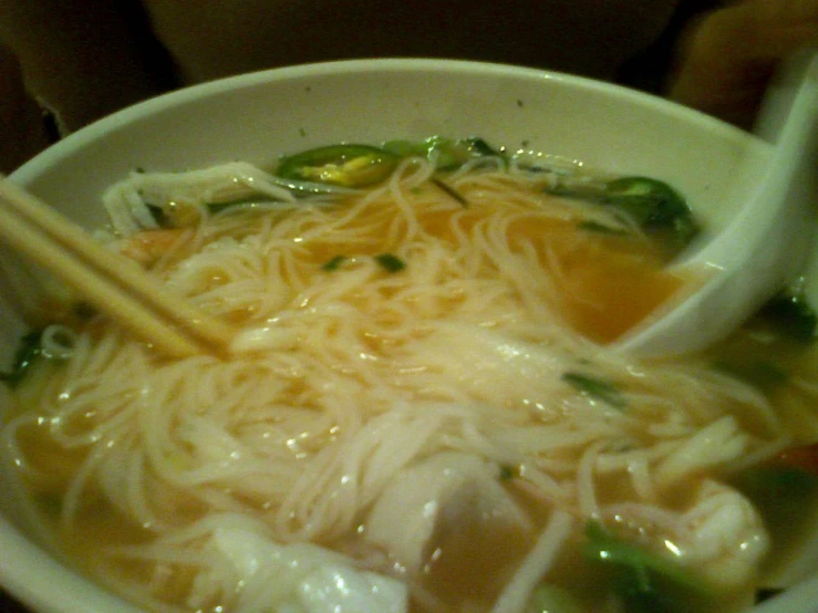 a bowl of noodles with a ladle of vegetable