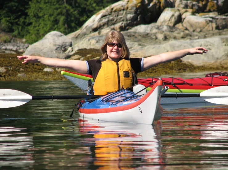 a woman sitting on top of a kayak in the middle of water