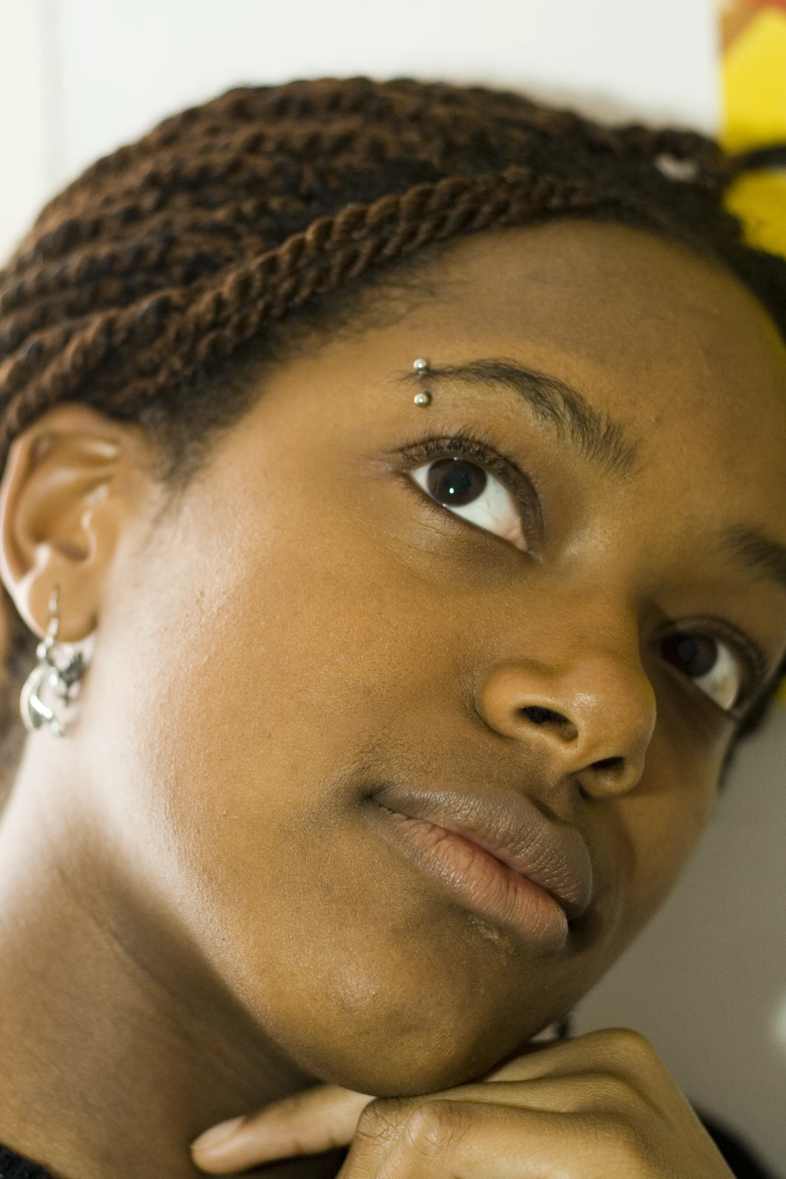 a woman wearing large earrings, with one ear wrapped around her head