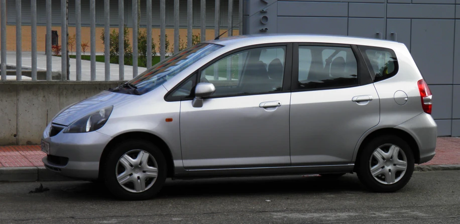 the silver car is parked on the side of the street