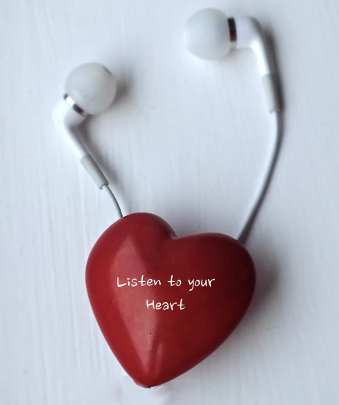 a red heart hanging from the side of a headphone