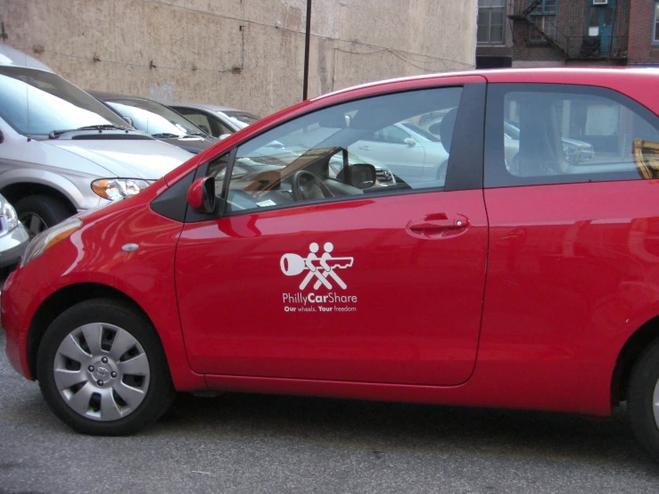 the red car is parked near the curb